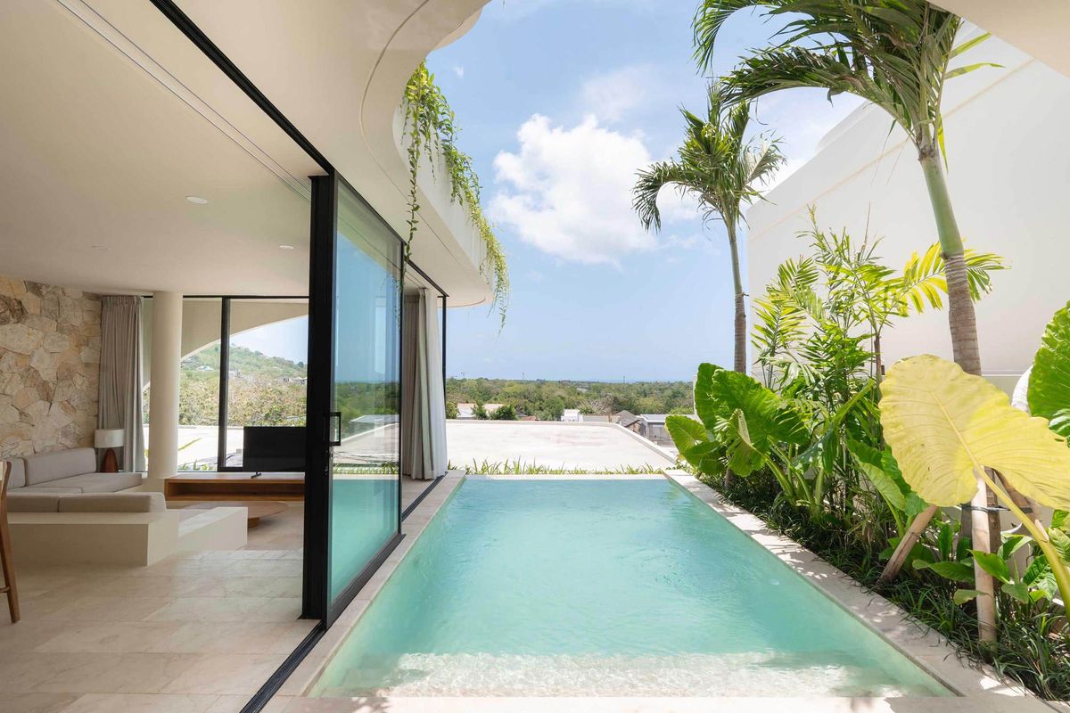 Modern villa with sliding glass walls, a private pool and a tropical garden